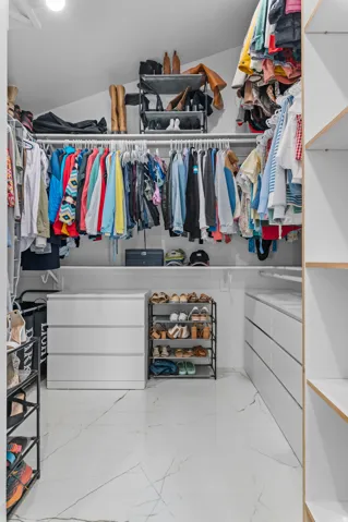 Custom closet system featuring built-in shelving, hanging rods, and integrated drawer units