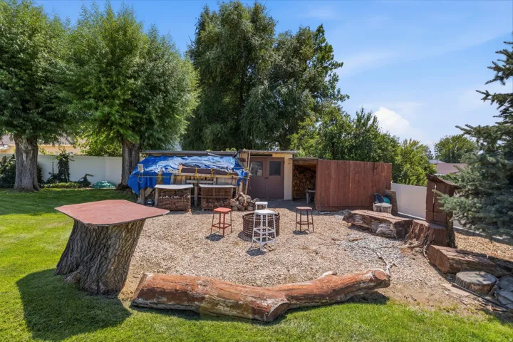 Backyard fire pit area another area to gather has  log seating, a woodshed, and sunset views down to Utah Lake.