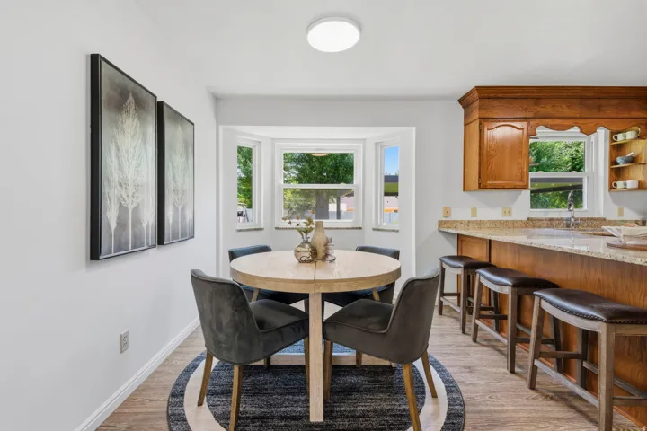 Casual dining area with a bay window that looks out to backyard.