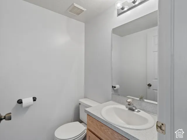 Bathroom featuring a built-in vanity with wood-finish cabinetry, a white oval sink, and a speckled countertop