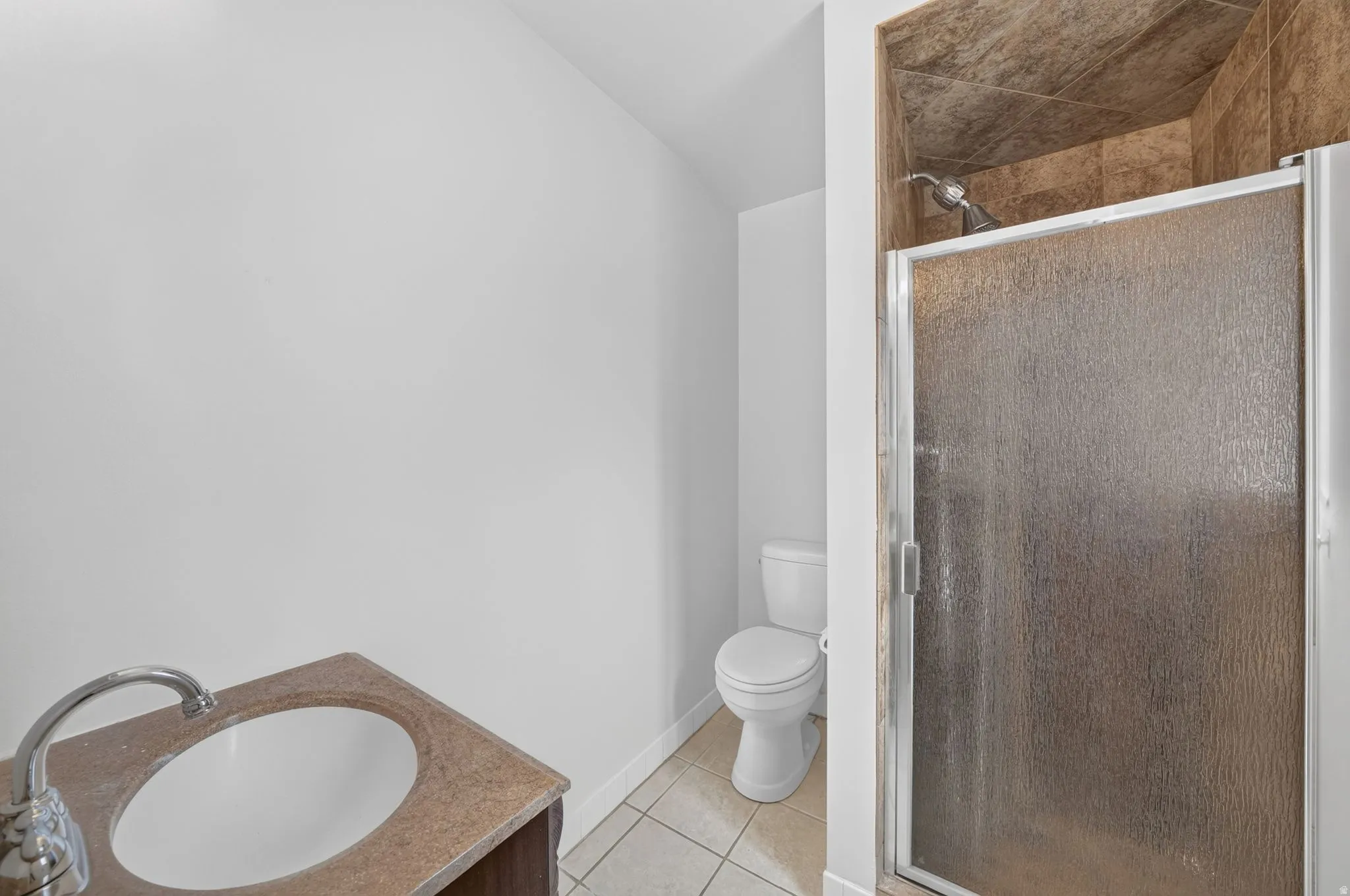 Bathroom featuring a vanity with a circular sink, polished chrome faucet, and a light-toned countertop