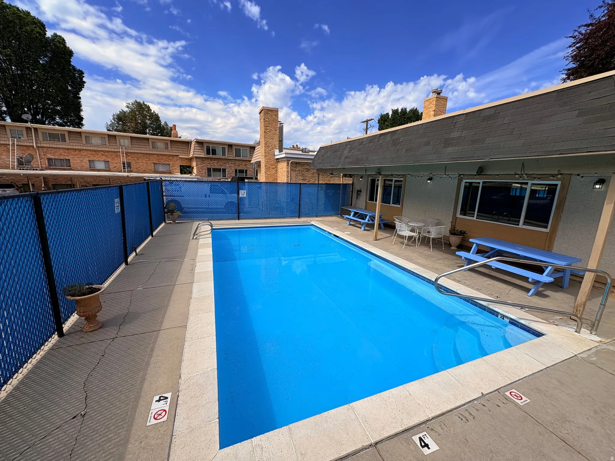 Rectangular swimming pool with a blue interior finish and concrete decking