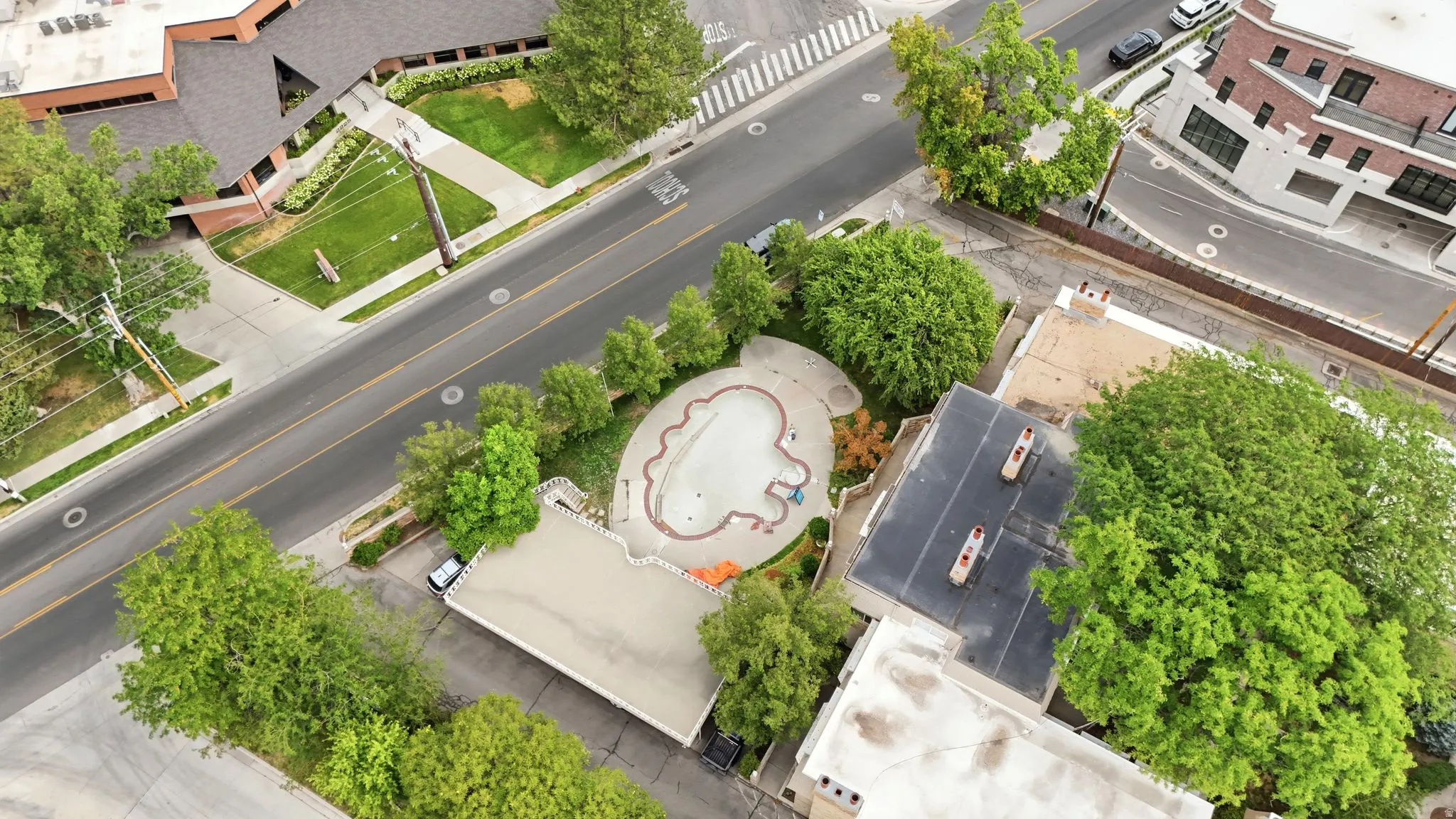 Aerial perspective showcasing diverse architectural styles, mature trees, and a patterned hardscaped area