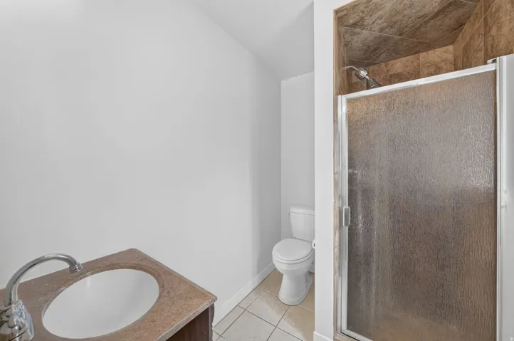 Bathroom featuring a vanity with a circular sink, polished chrome faucet, and a light-toned countertop