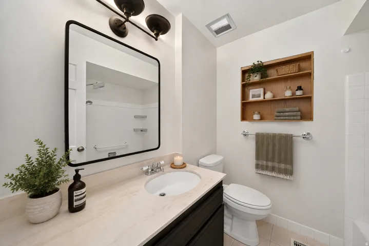 Vanity with light-toned countertop, undermount sink, and black base