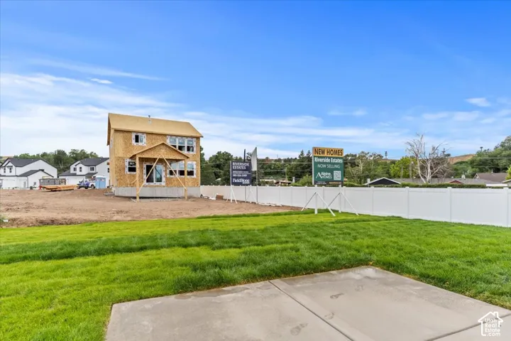 Spacious lot featuring a newly laid concrete patio and verdant lawn