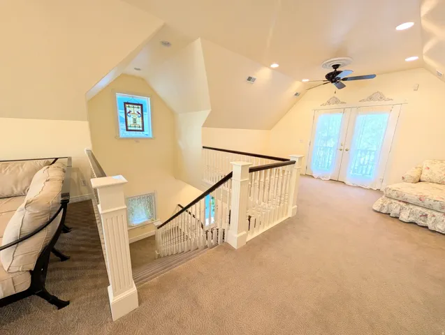 Carpeted loft area featuring a white baluster railing with dark wood top rail, recessed lighting, and a ceiling fan