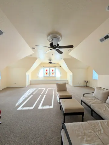 Spacious Upper level room featuring sloped ceilings, recessed lighting, and two ceiling fans
