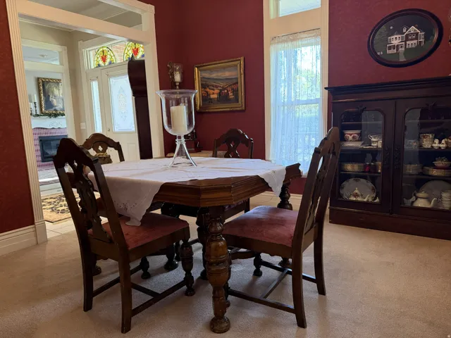 Dining space featuring red textured walls, a classic wood dining table, and light-colored carpeting