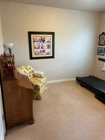 Carpeted room featuring neutral wall tones and white baseboards