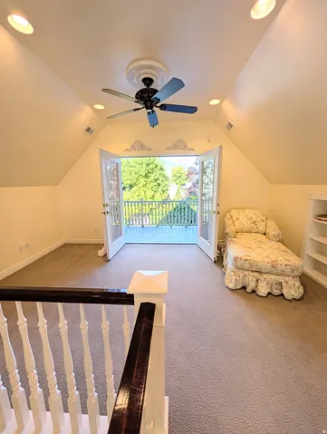Carpeted upper-level space featuring a vaulted ceiling with recessed lighting and a ceiling fan