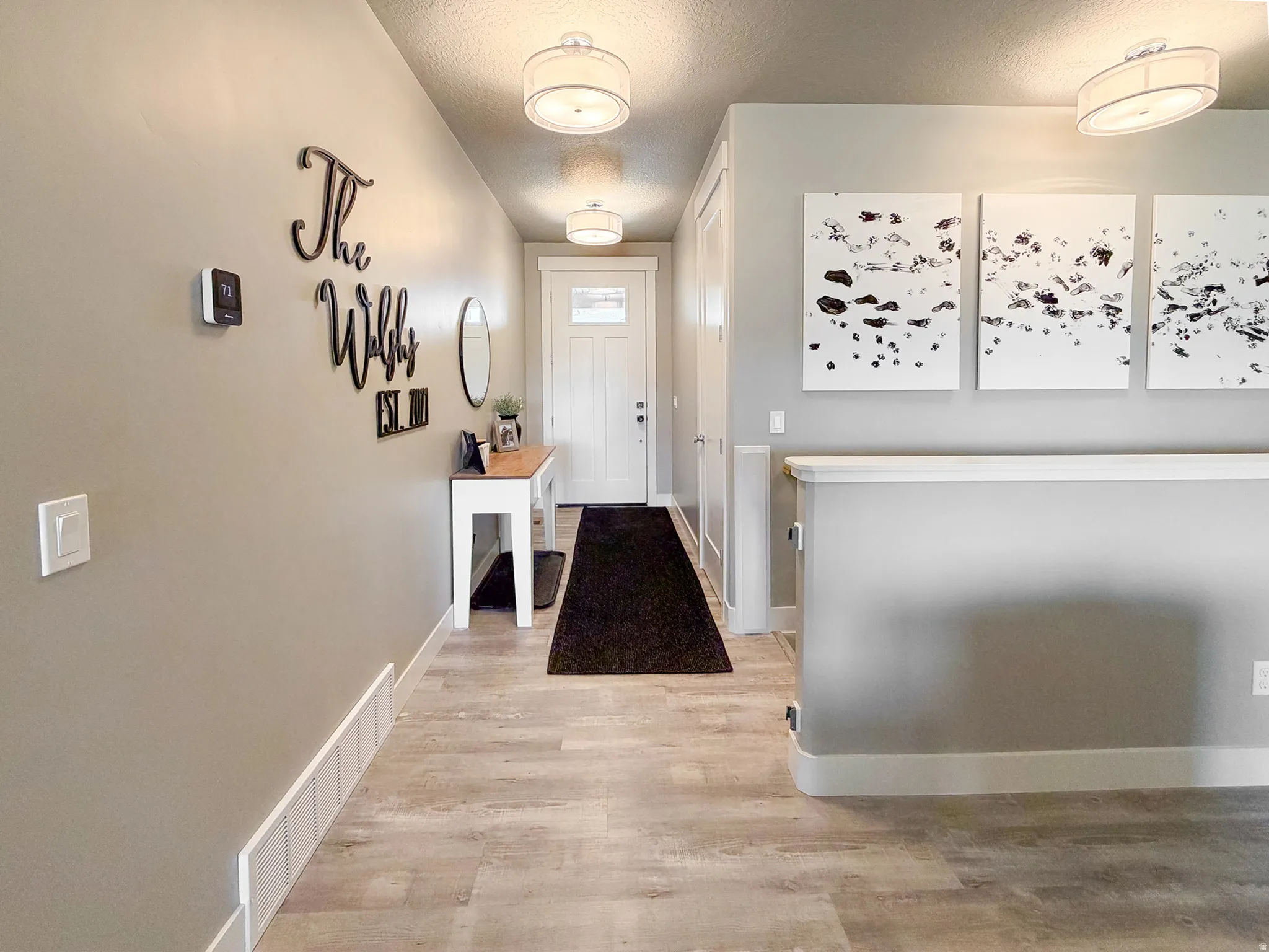 Foyer featuring plank-style flooring, a console table, and contemporary ceiling light fixtures