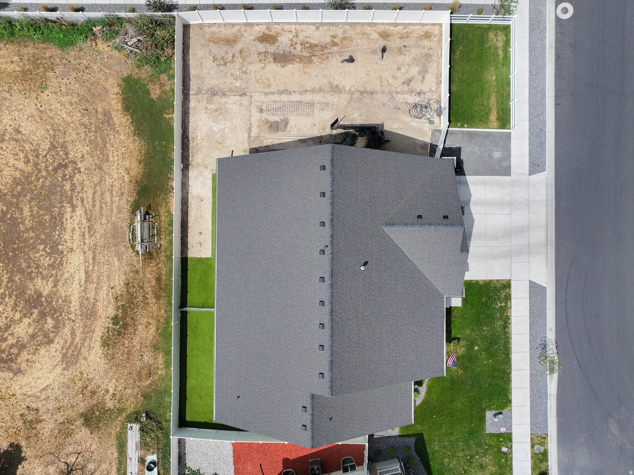 Newly constructed residence featuring a dark shingle roof and concrete driveway