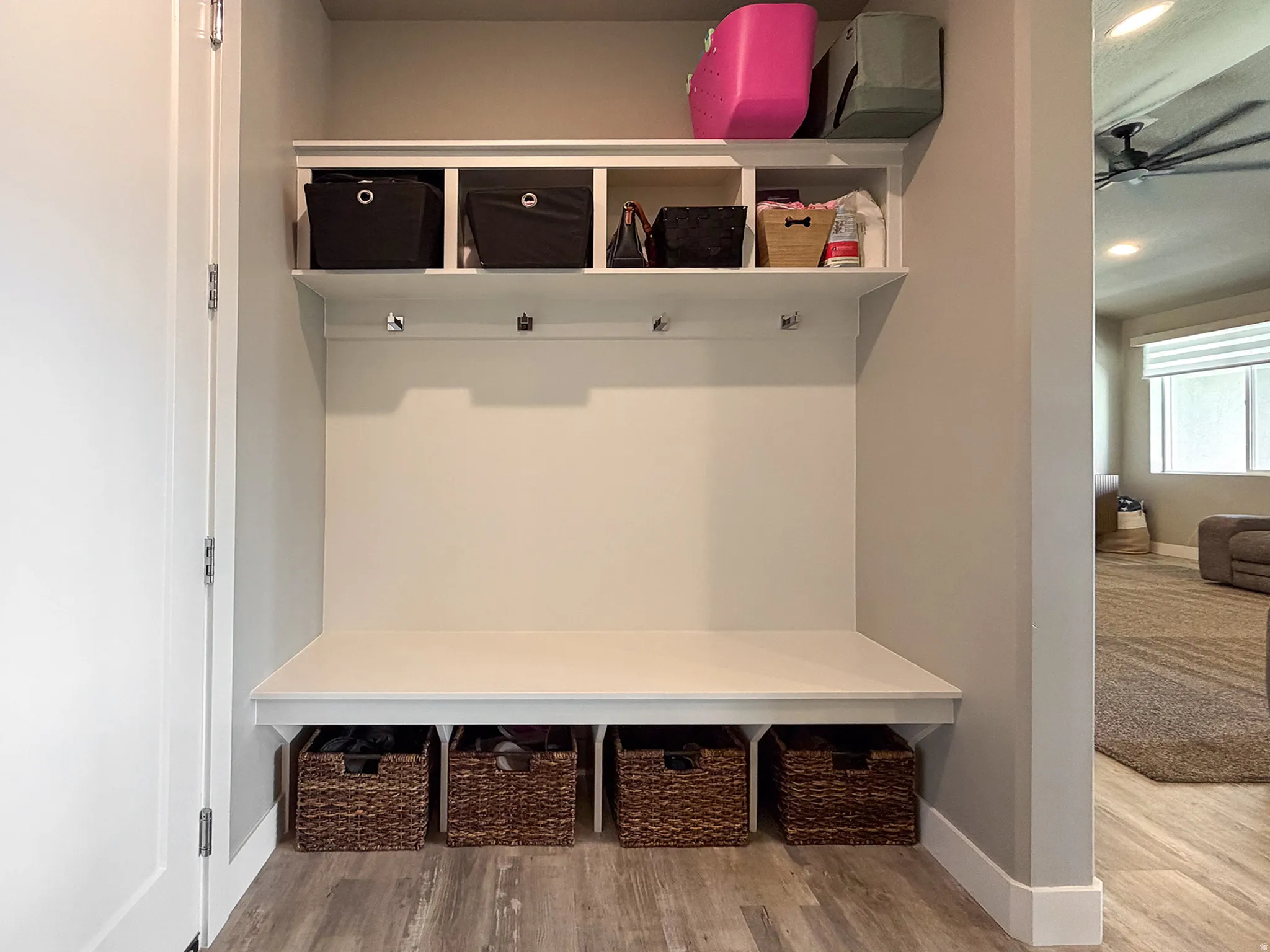 Built-in mudroom bench with cubby storage, upper shelving, and wall hooks