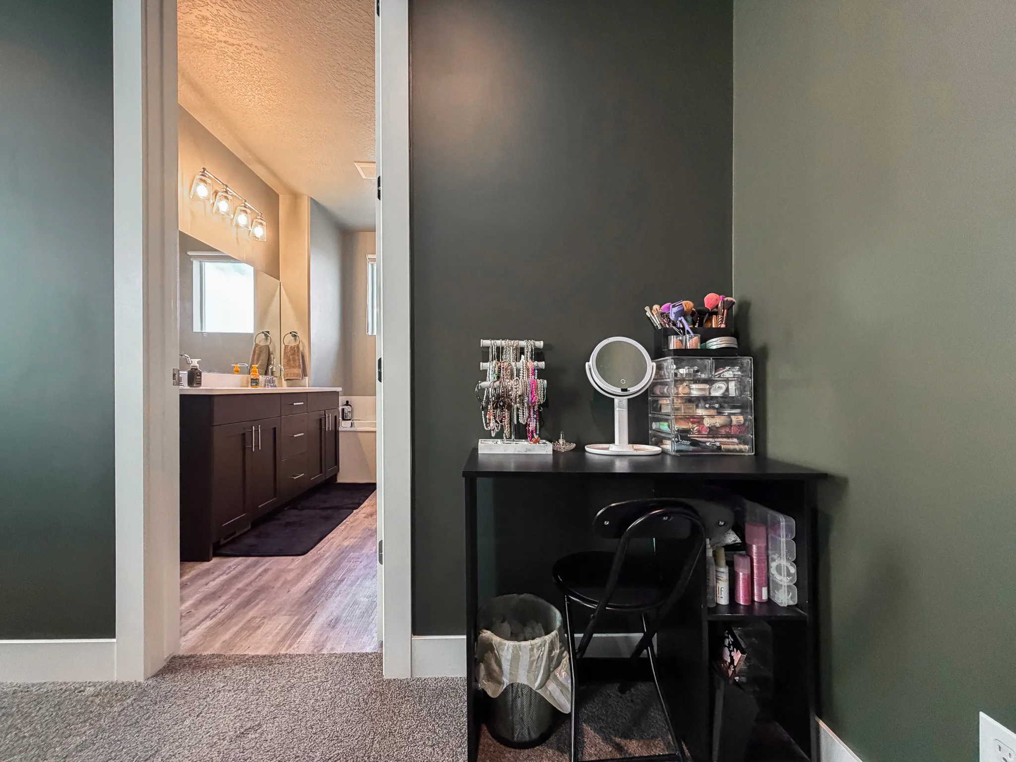 Bathroom featuring a dark wood vanity with a light-toned countertop, a built-in bathtub, and a four-light fixture