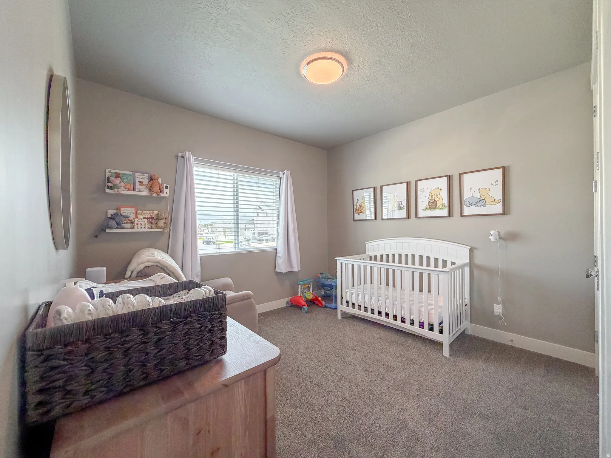 Room featuring warm gray wall paint, a window with horizontal blinds, and a built-in ceiling light fixture