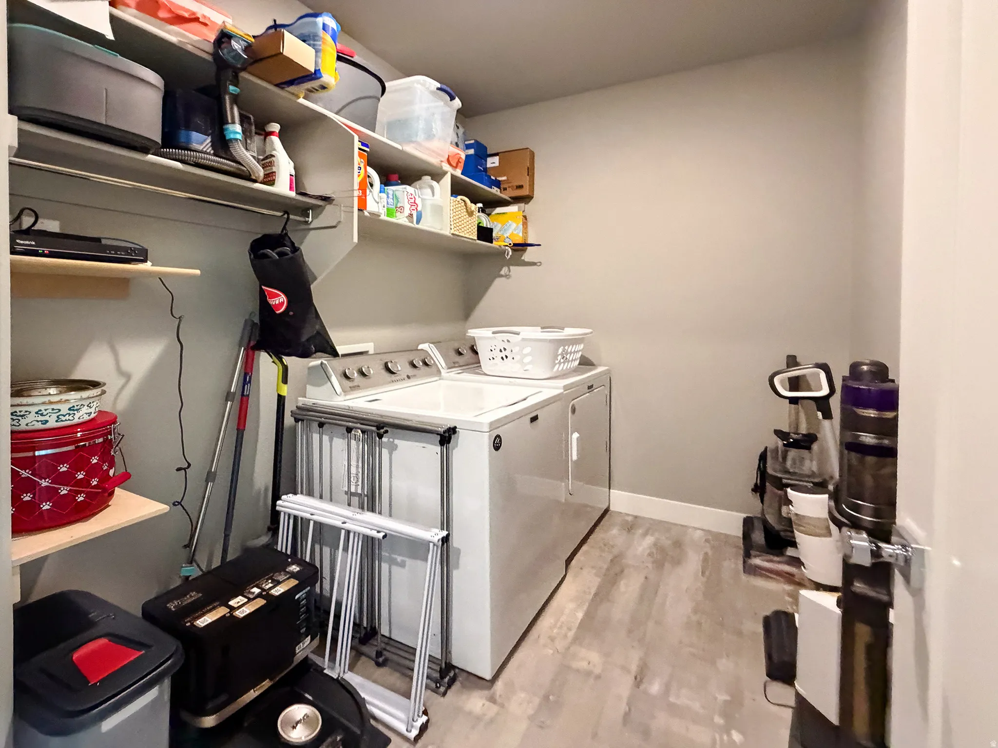 Dedicated laundry area featuring a light-toned wood-finish floor and neutral wall paint
