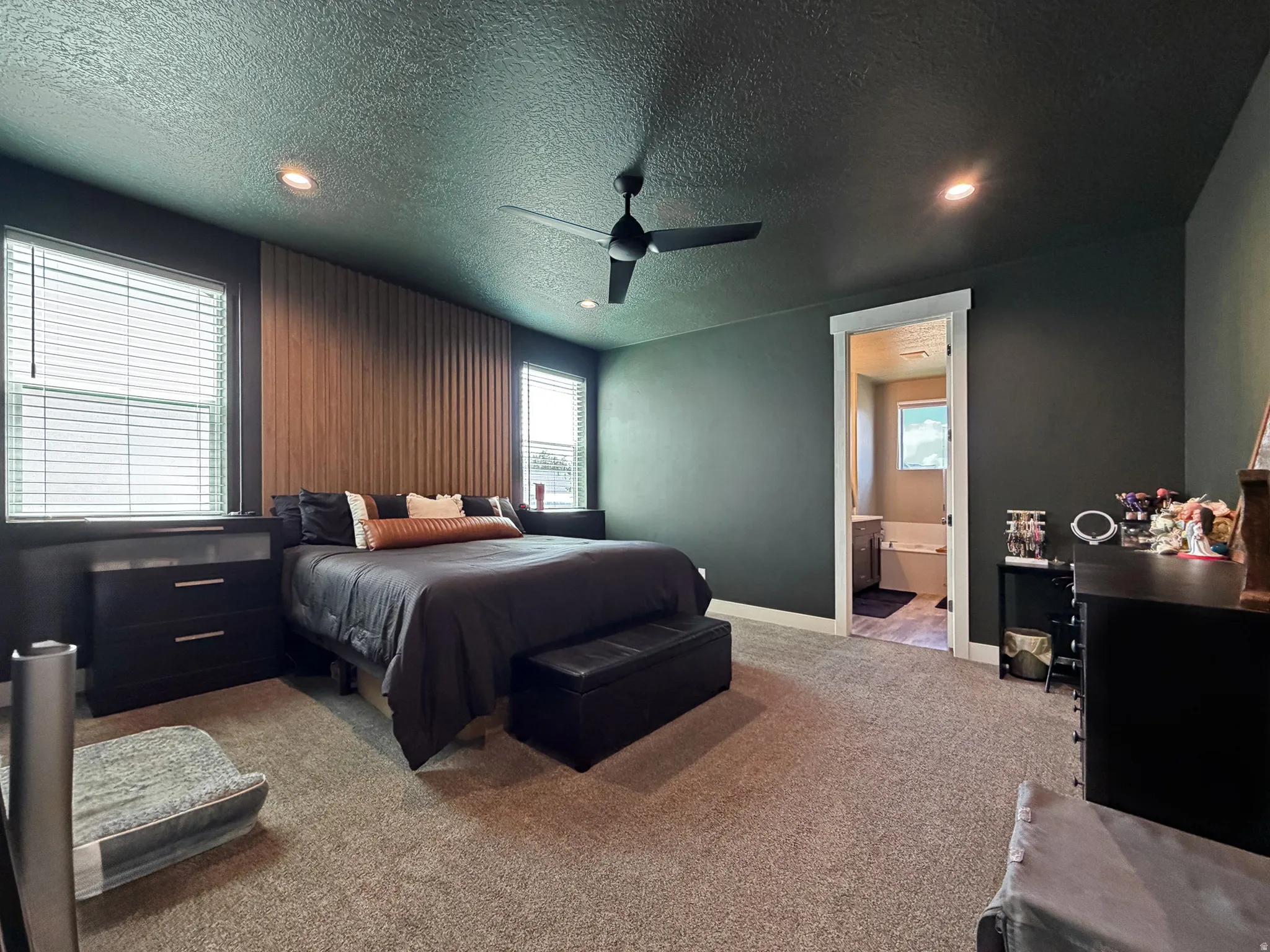 Bedroom featuring dark painted walls and a prominent wood-finish accent wall with vertical slat detailing