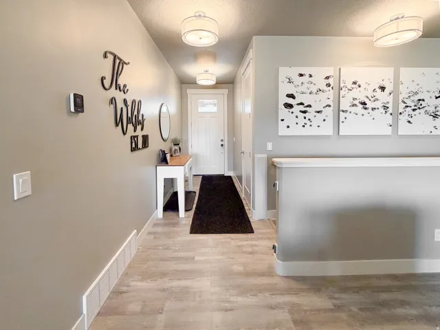 Foyer featuring plank-style flooring, a console table, and contemporary ceiling light fixtures