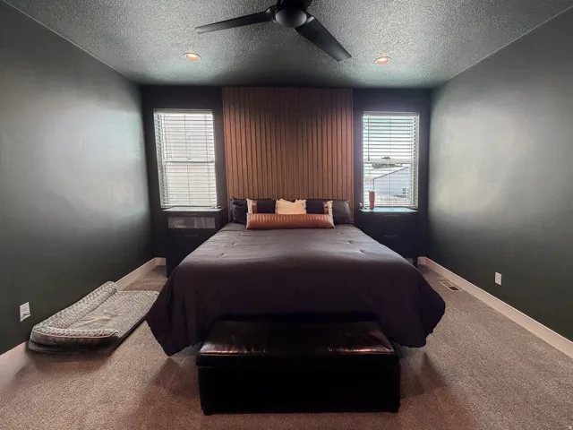 Bedroom featuring dark wall paint and a textured wood-panel accent wall
