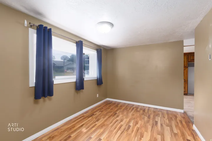Room featuring wood-finish flooring, neutral wall tones, and white baseboards