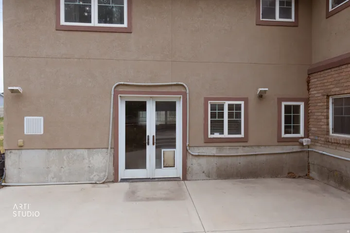 Concrete patio area with direct access via white-framed double doors
