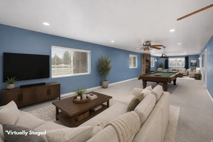 Expansive room featuring blue walls, recessed lighting, and light-toned carpeting