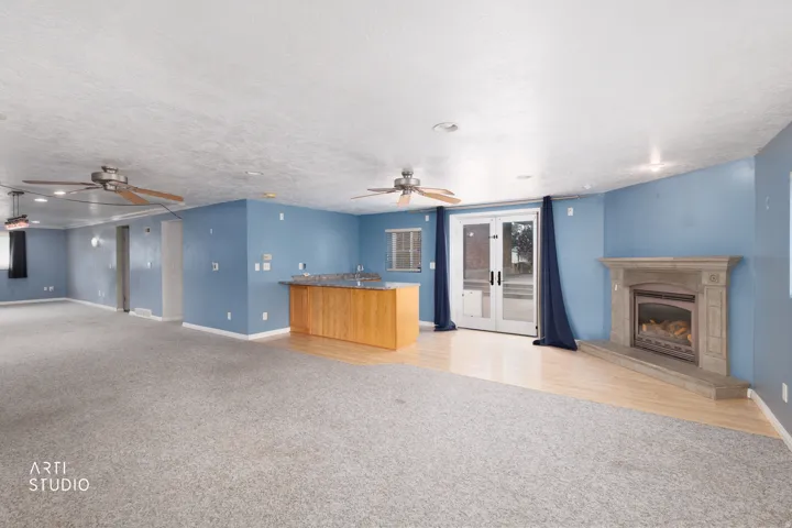 Spacious interior with a built-in wet bar featuring wood cabinetry and a stone-finish countertop