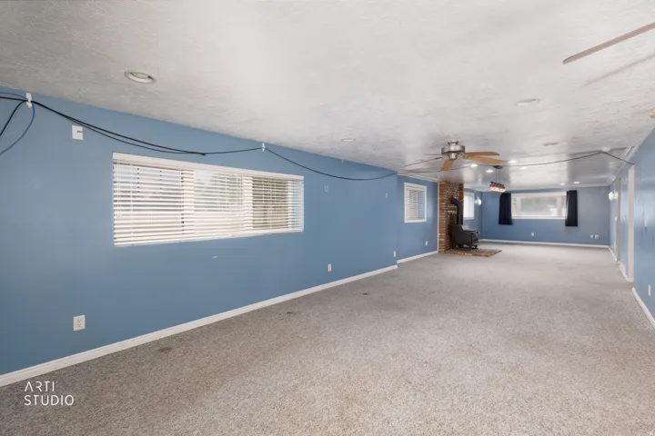 Spacious room featuring light gray carpeting, ceiling-mounted lighting, and painted walls