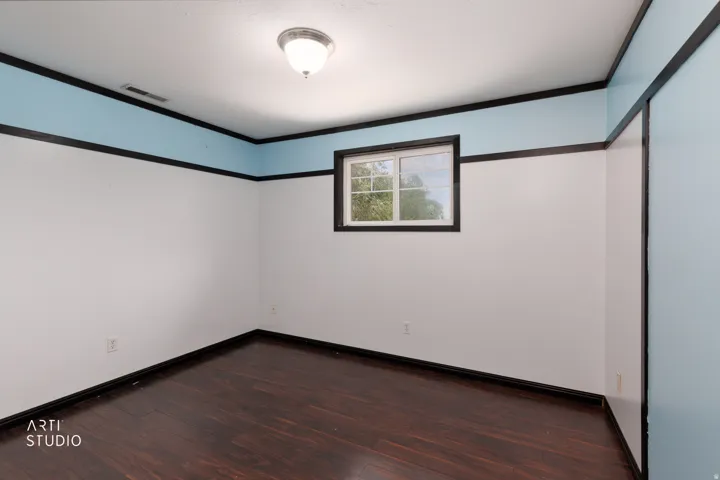 Room featuring dark wood-finish flooring, white and light blue painted walls, and dark trim