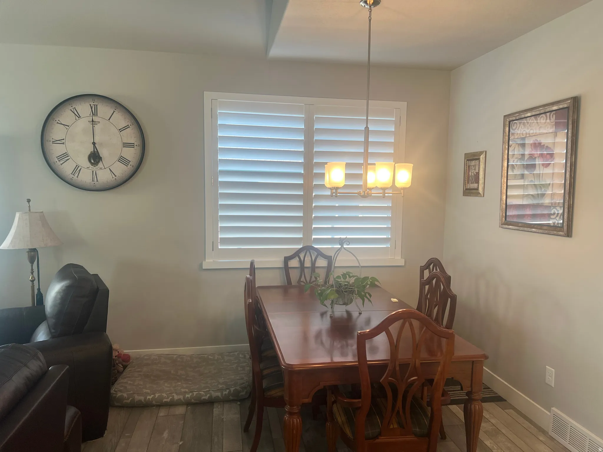 Dining area featuring wood-finish flooring and a contemporary chandelier