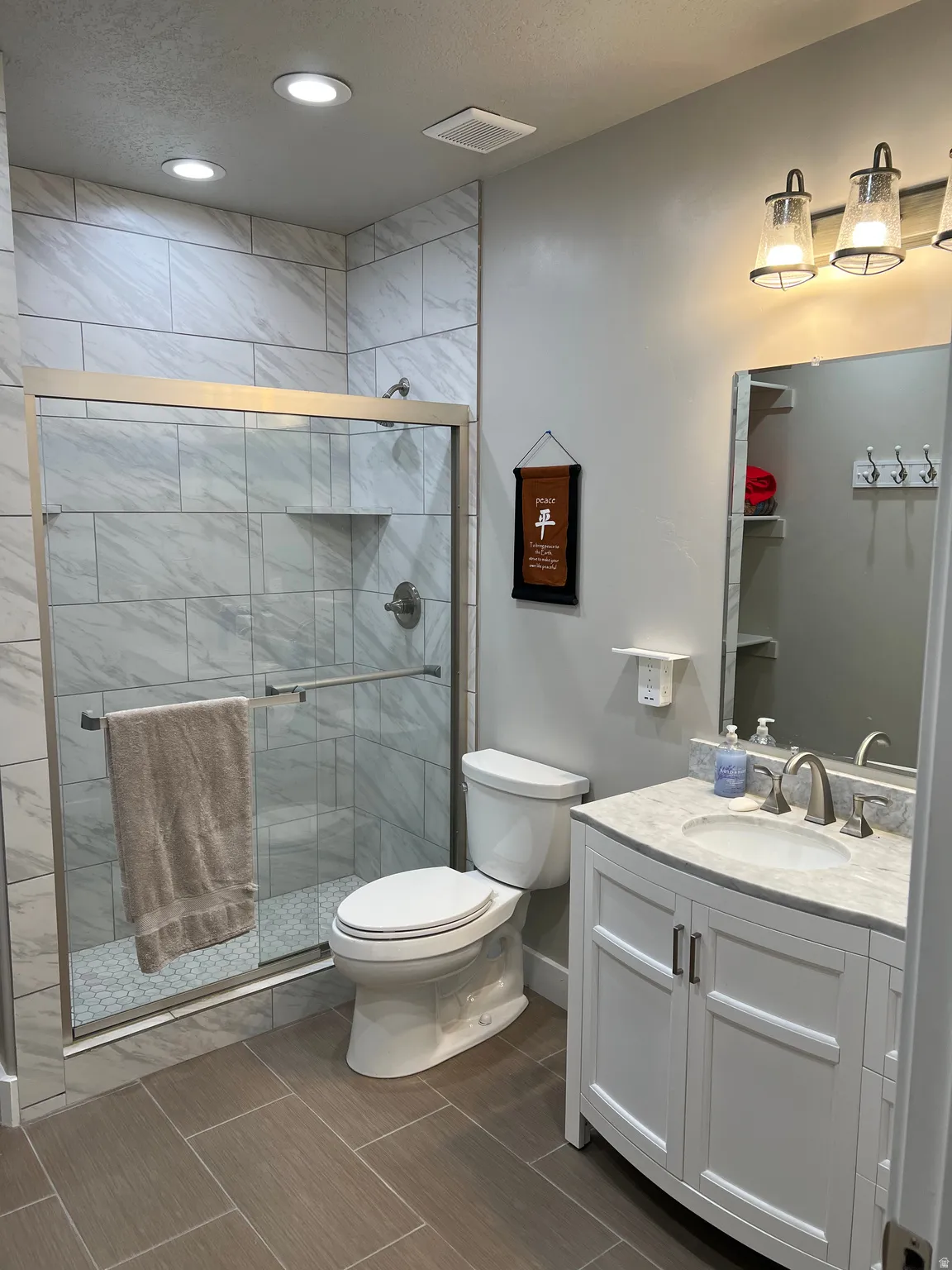 Tiled shower with glass enclosure and built-in niche