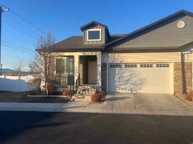 Modern facade featuring horizontal siding, a stone accent column, and an attached garage with panel detailing