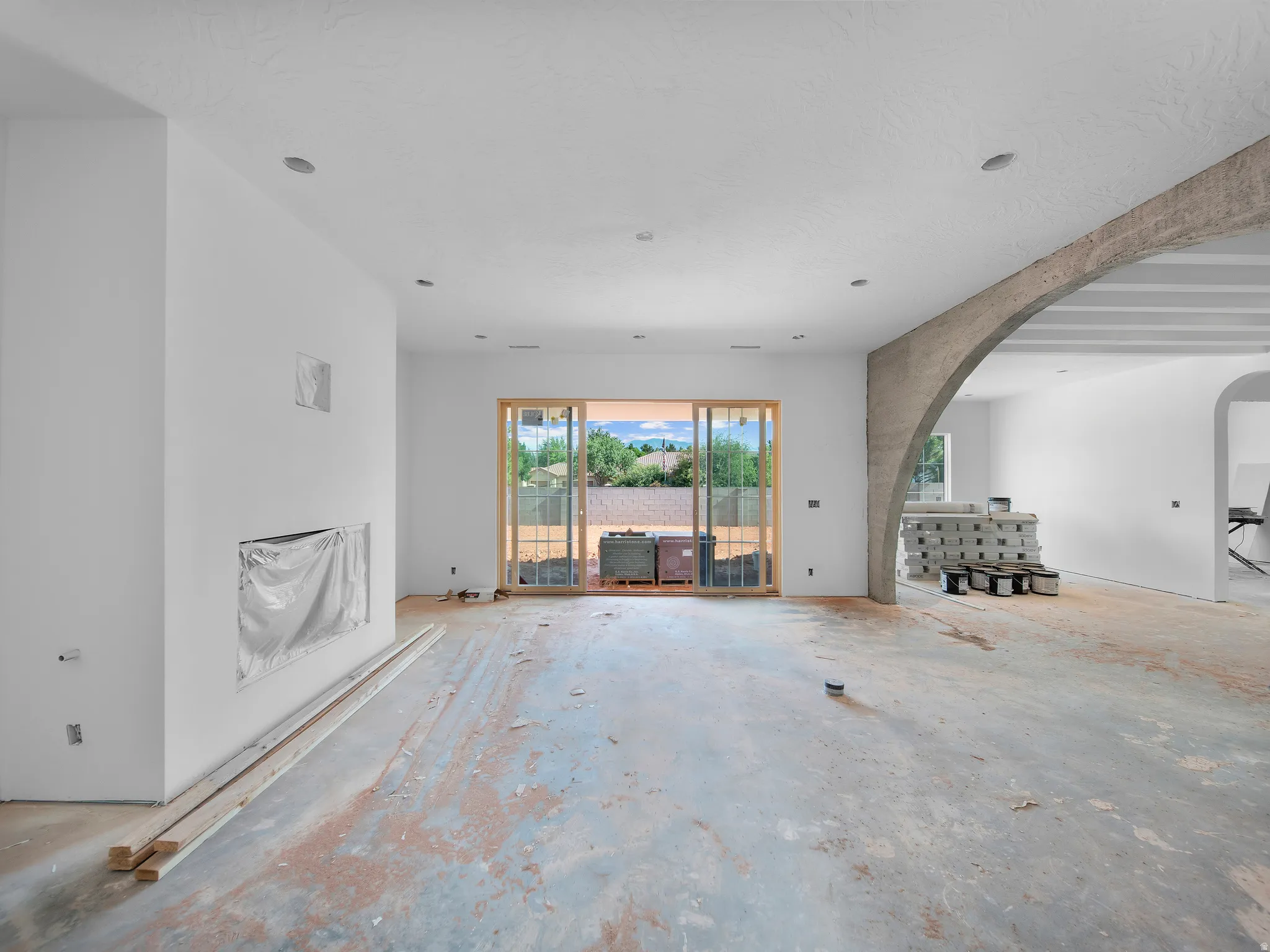 Expansive open concept interior featuring a built-in fireplace niche, recessed lighting, and a large sliding glass door