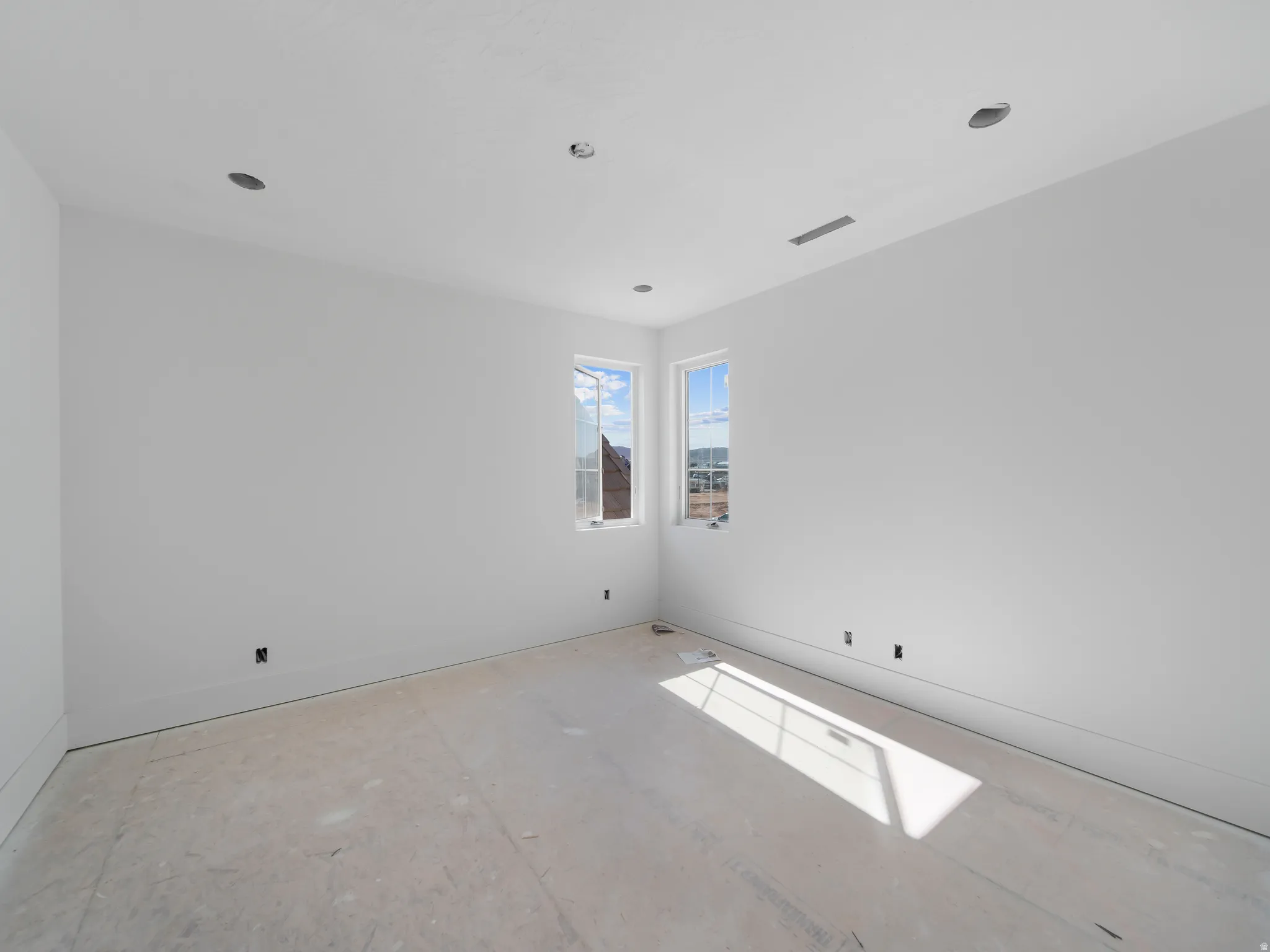 Room featuring multiple windows, recessed ceiling lighting, and baseboard trim
