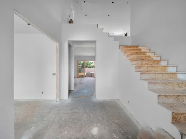 Contemporary interior featuring an unfinished staircase, concrete flooring, recessed lighting, and an open concept layout