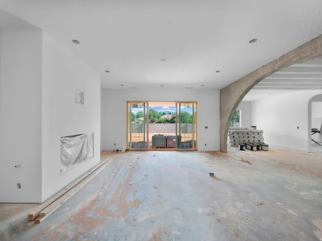 Expansive open concept interior featuring a built-in fireplace niche, recessed lighting, and a large sliding glass door