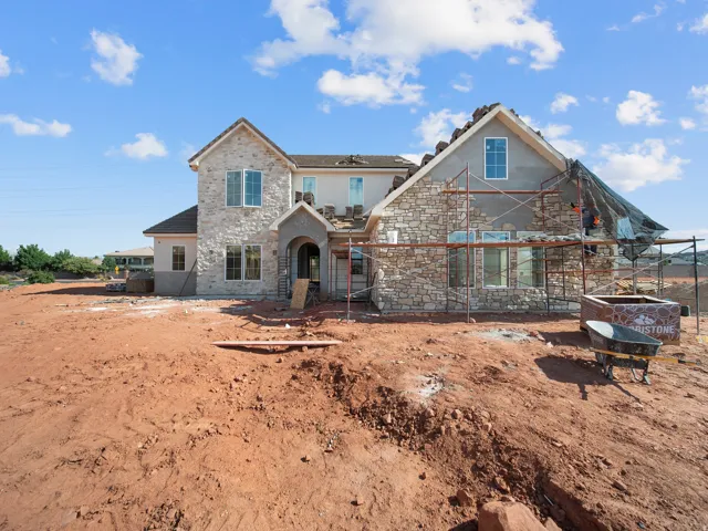 Stone veneer facade with varied textures, arched entryway, and multiple window placements