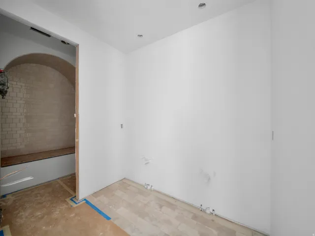 Arched entryway with subway tile wall and integrated bench