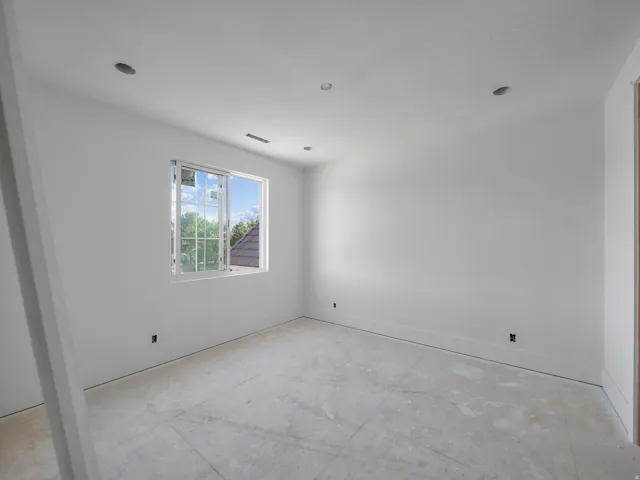 Unfinished room featuring a single window with grids, white trim, recessed lighting, and a neutral color palette
