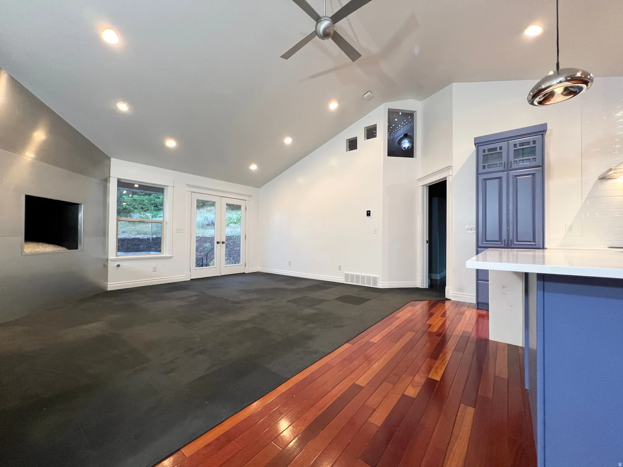 Vaulted ceilings with recessed lighting and a ceiling fan
