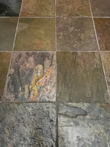 Textured square tile flooring in a multi-color palette featuring natural variations in tone and pattern