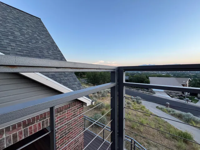 Balcony with contemporary cable railing and composite decking, offering expansive neighborhood views and distant mountains