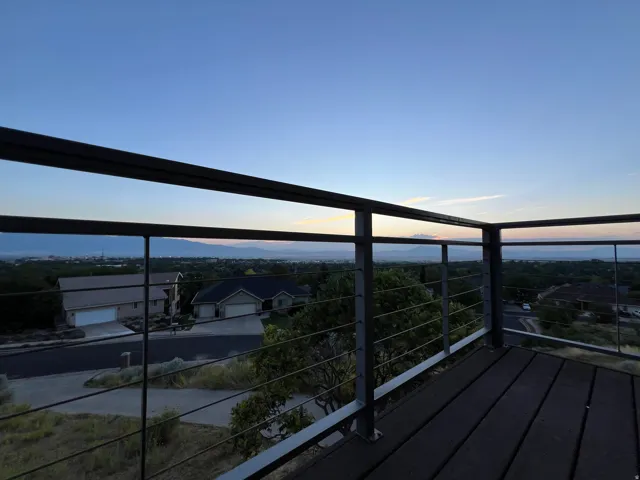 Deck with dark wood-finish flooring and cable railing