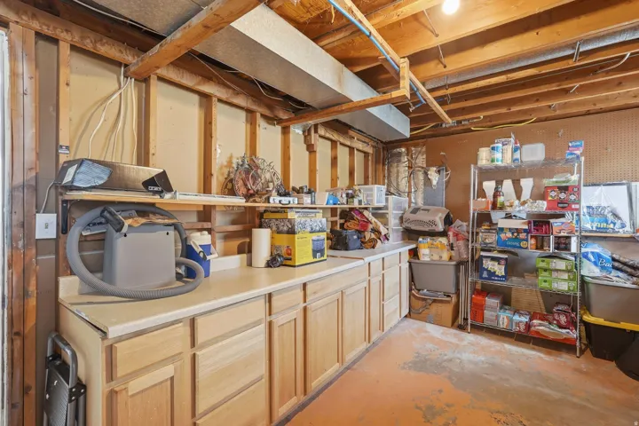 Unfinished basement space featuring exposed wood framing and a concrete floor