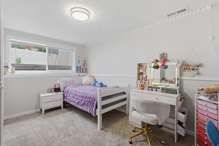 Carpeted room featuring a double-hung window with white trim, a flush-mount ceiling light, and white baseboards