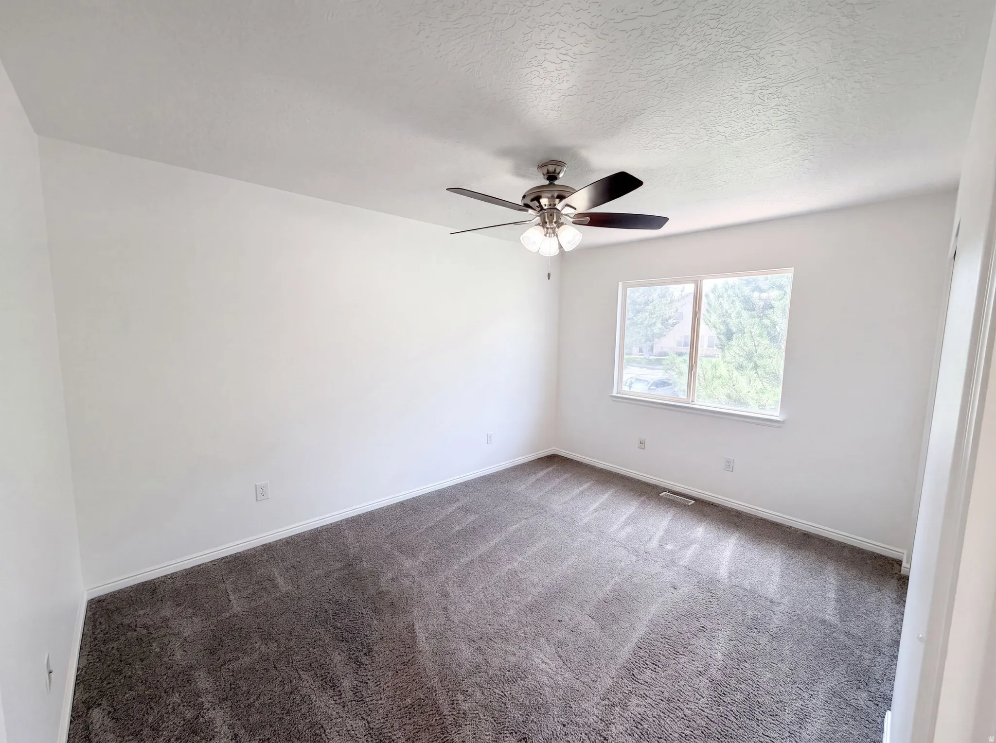 Bright room with neutral wall paint and gray patterned carpet