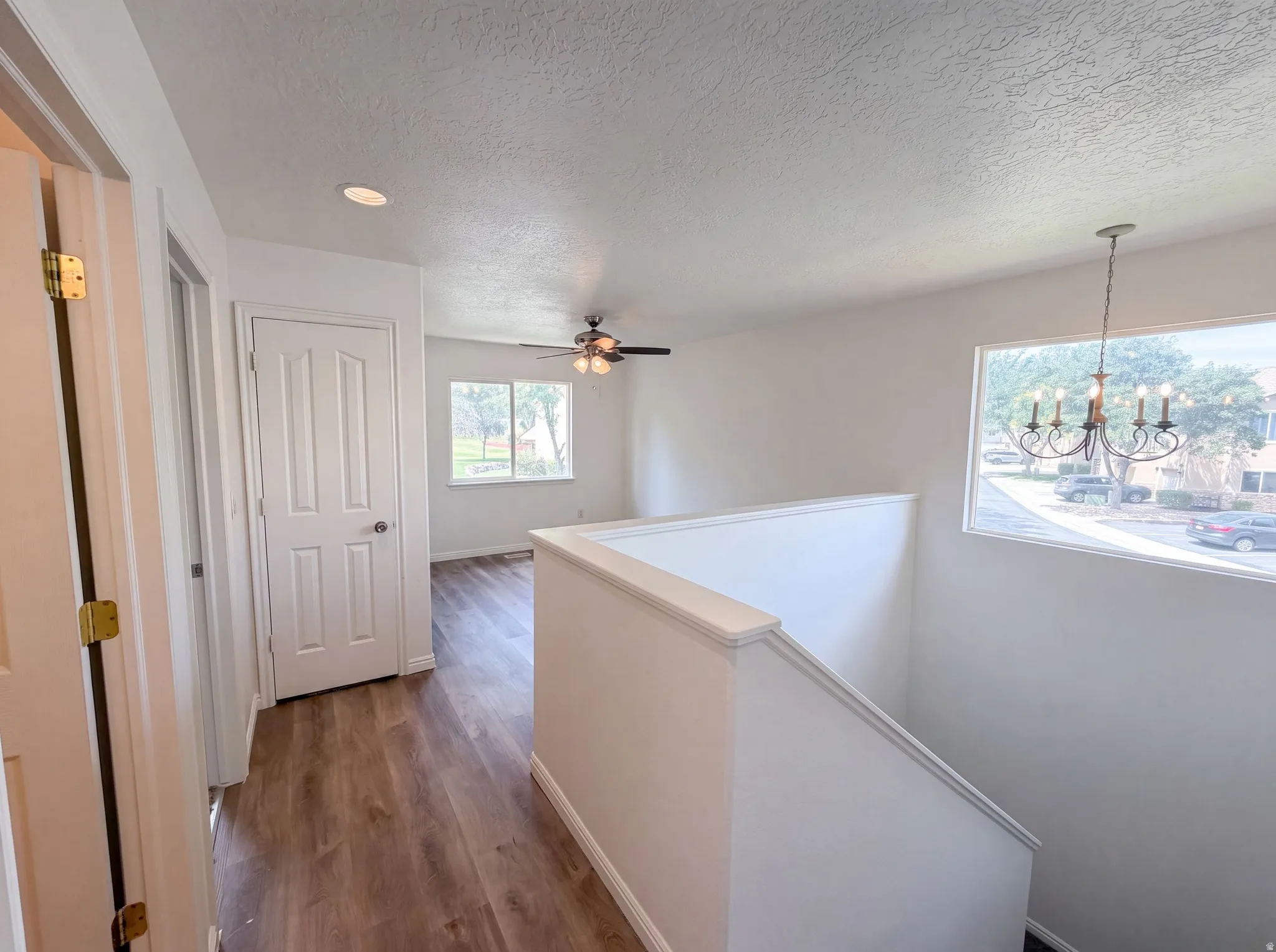 Open interior space featuring wood-finish flooring, white walls, and a recessed ceiling light