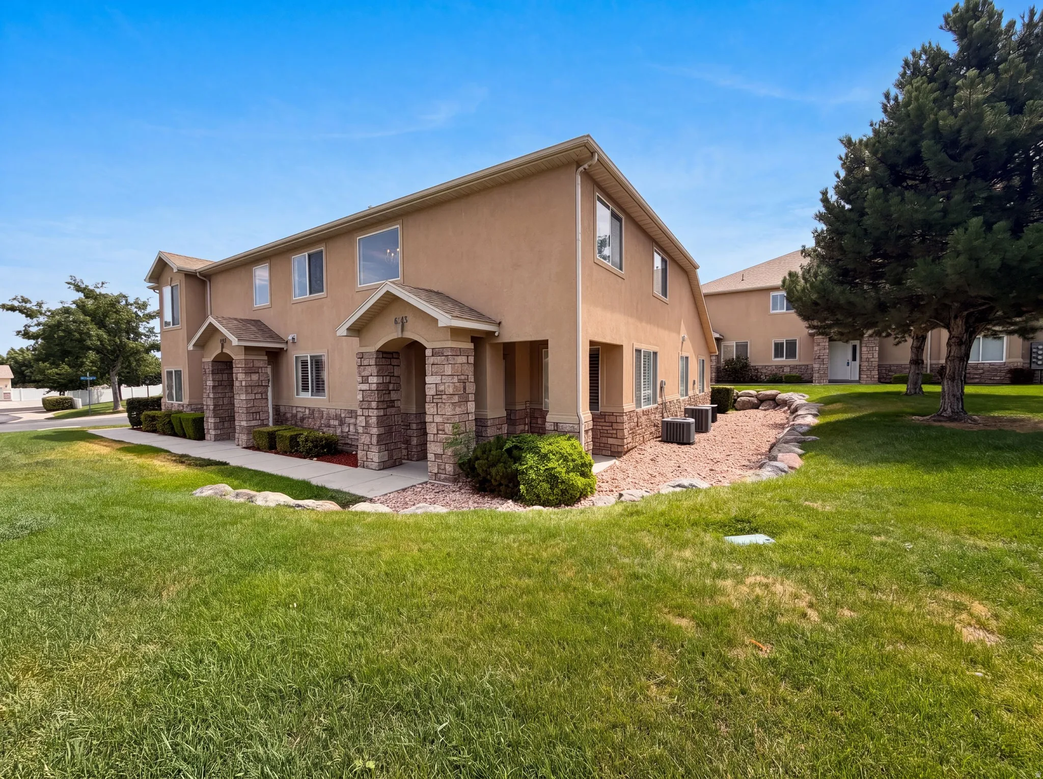 Multi-unit property with stucco exterior and stone veneer accents