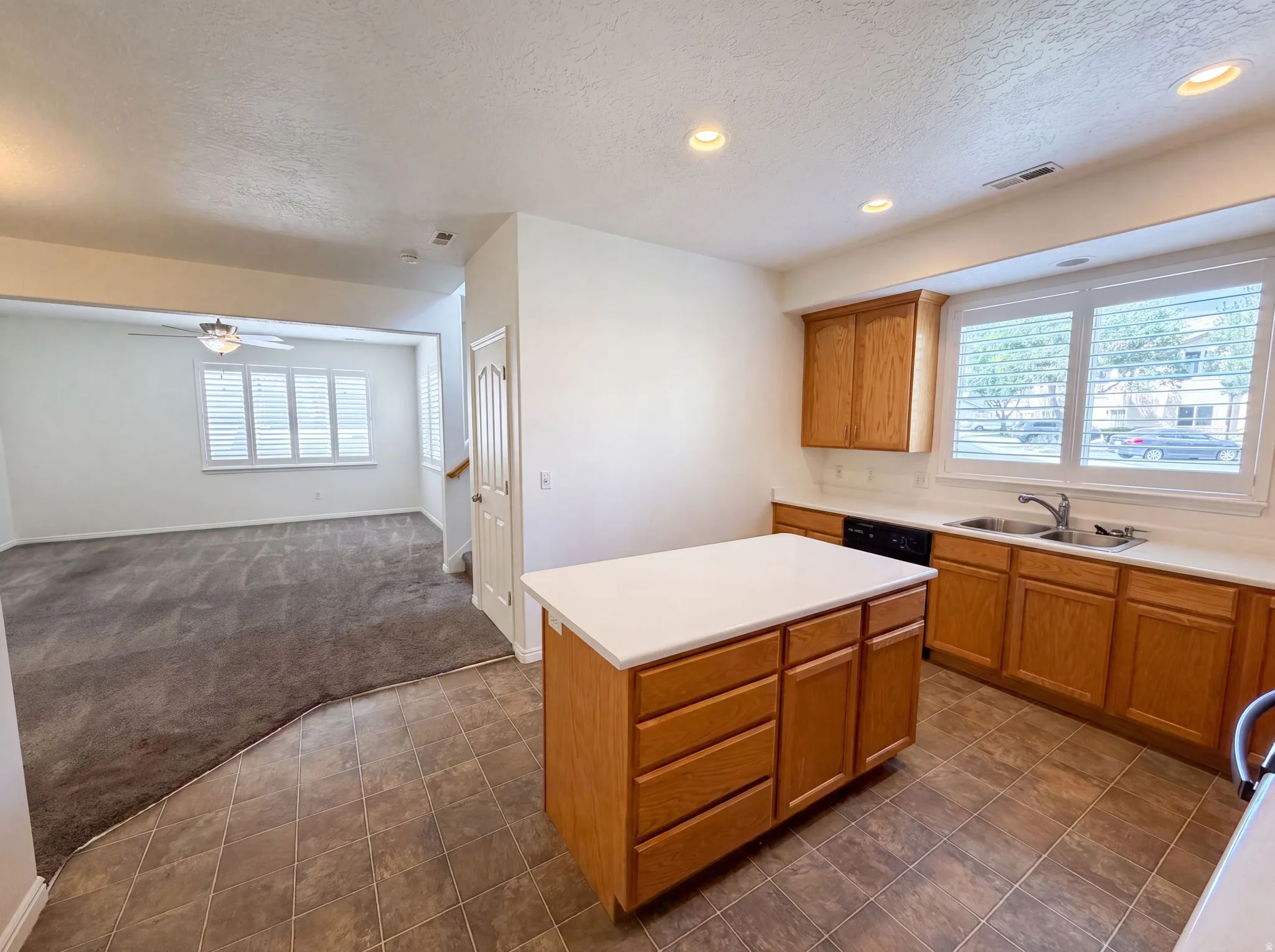 Kitchen featuring wood cabinetry, white countertops, stainless steel sink, and recessed lighting